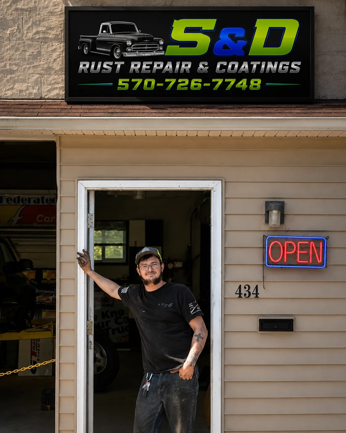 Sam, owner of S&D Rust Repair & Coatings, standing in the shop doorway