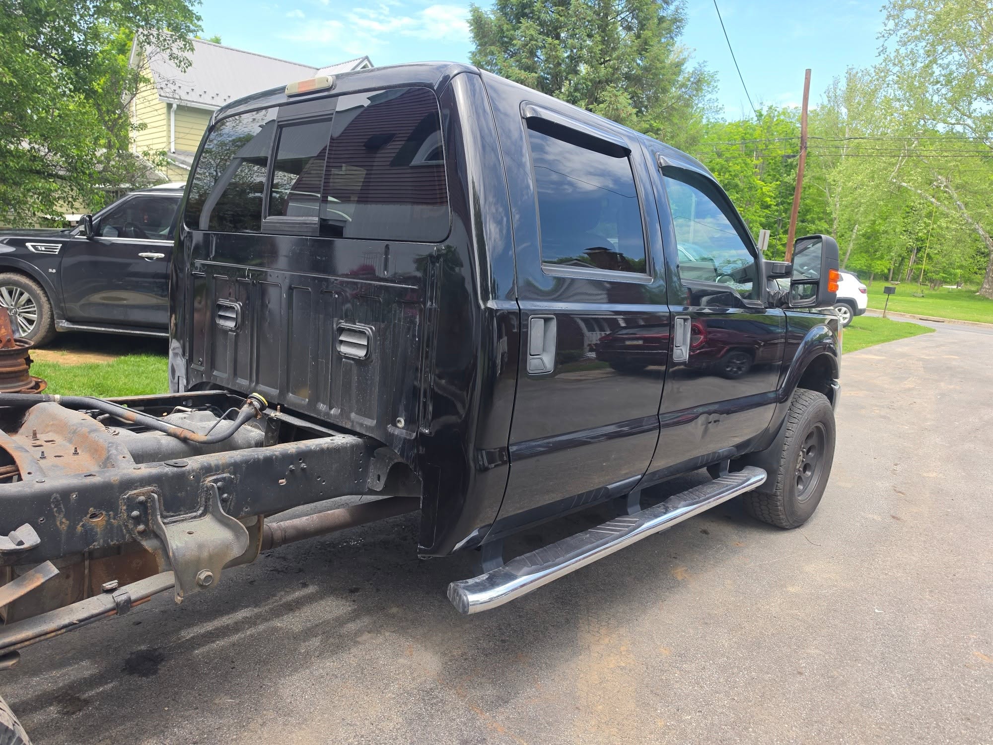 Rear view of a black Ford Super Duty with the bed removed for repair access